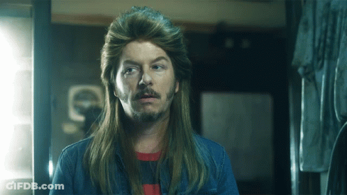 A Man With Long Hair And A Beard Is Wearing A Wig GIF