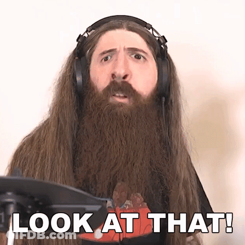 A Man With Long Hair And A Beard Is Wearing Headphones And Says Look At That GIF