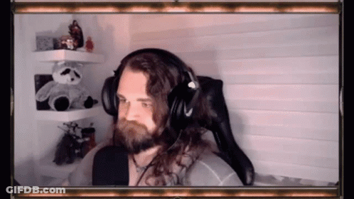 A Man With Long Hair And A Beard Is Wearing Headphones . GIF