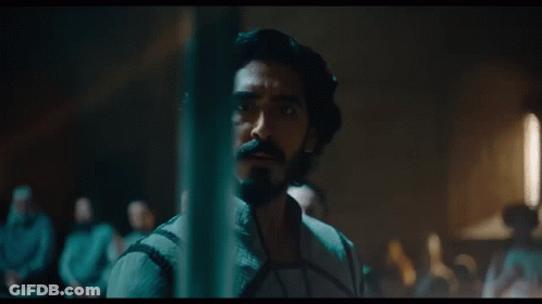 A Man With Long Hair And A Beard Looks At Something GIF