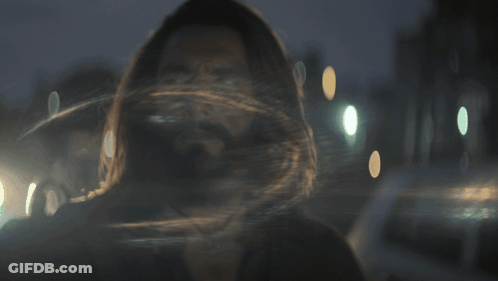 A Man With Long Hair And A Beard Looks At Something GIF