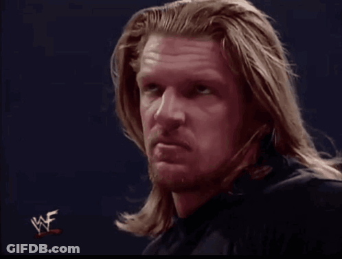 A Man With Long Hair And A Beard Looks At The Camera With A Wwe Logo In The Corner GIF