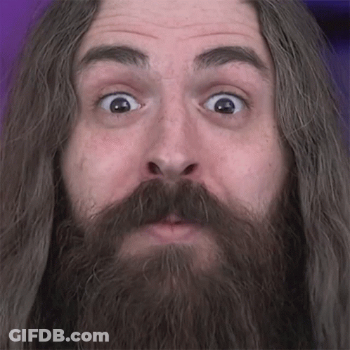 A Man With Long Hair And A Beard Looks Surprised GIF