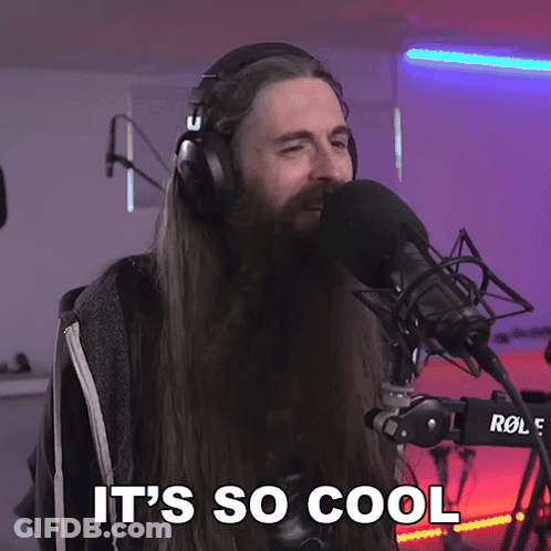 A Man With Long Hair And A Beard Singing Into A Microphone With The Words It 'S So Cool Above Him GIF