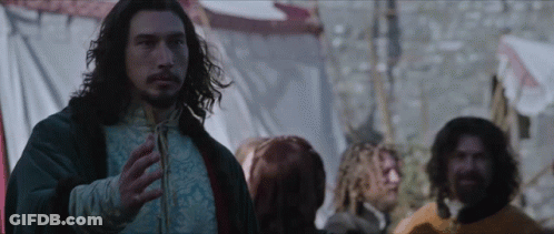 A Man With Long Hair And A Beard Stands In Front Of A Crowd GIF