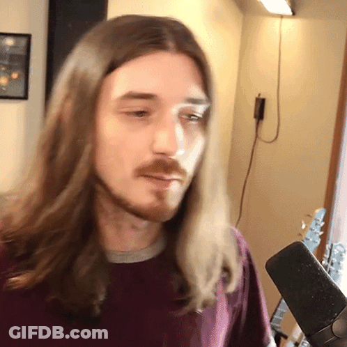 Man With Long Hair And Beard In Front Of Microphone GIF