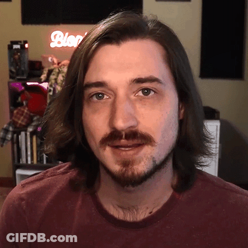 Man With Long Hair And Beard Standing In Front Of Blog Sign GIF