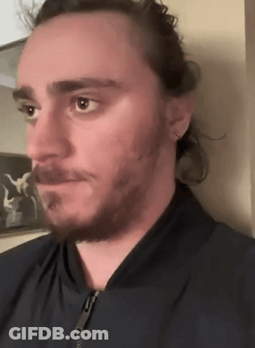 A Man With Long Hair And A Beard Wearing A Black Jacket GIF