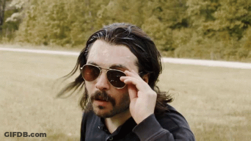 A Man With Long Hair And A Beard Wearing A Pair Of Sunglasses GIF