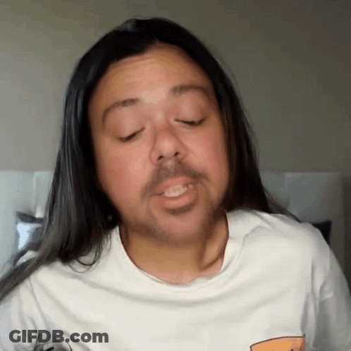 A Man With Long Hair And A Beard Wearing A White Shirt GIF
