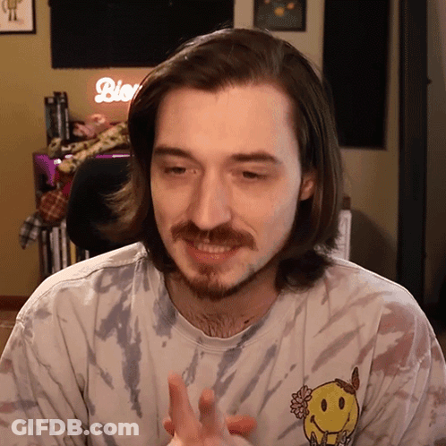 Man With Long Hair And Beard Wearing Tie Dye Shirt With Smiley Face Back GIF