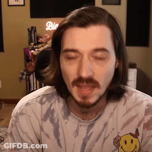 Man With Long Hair And Beard Wearing Tie Dye Shirt With Smiley Face GIF