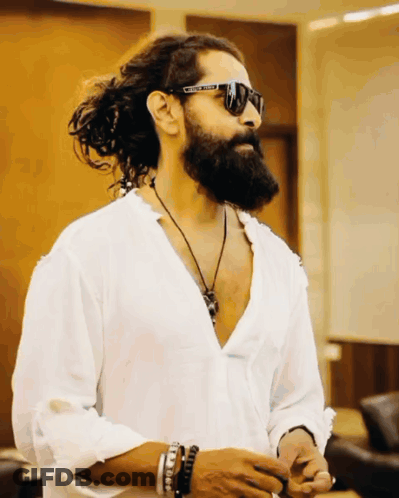 A Man With Long Hair And A Beard Wears A White Shirt And Sunglasses With The Word United On Them GIF