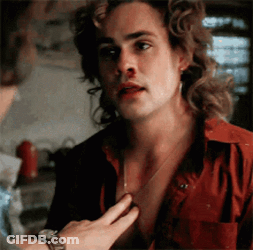 A Man With Long Hair And A Bloody Nose Is Being Touched By Another Man . GIF