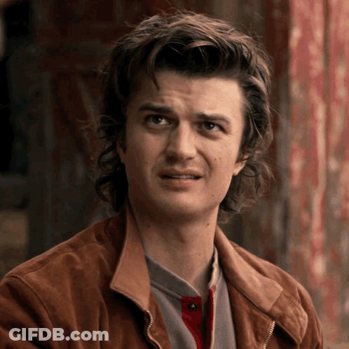 A Man With Long Hair And A Brown Jacket Is Making A Funny Face GIF