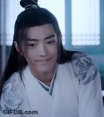 A Man With Long Hair And A Bun On His Head Is Wearing A White Kimono And Smiling . GIF