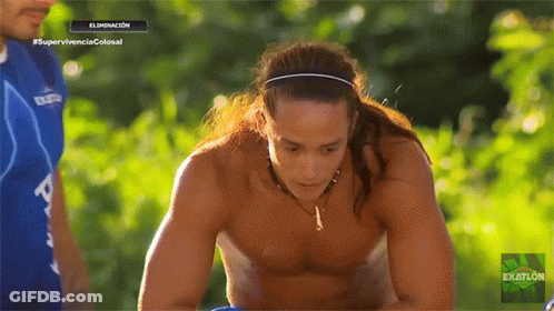 A Man With Long Hair And A Headband Is On A Television Screen That Says Exatlon GIF