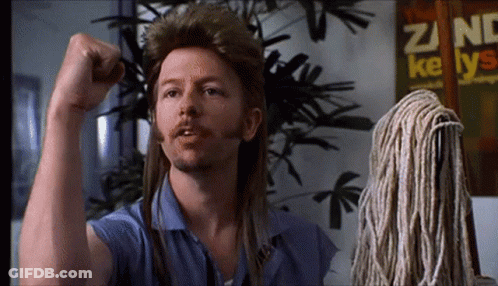 A Man With Long Hair And A Mop Has His Fist Up GIF