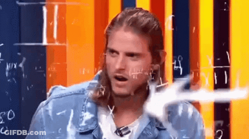 A Man With Long Hair And A Mullet Is Sitting In Front Of A Wall With Numbers Written On It . GIF
