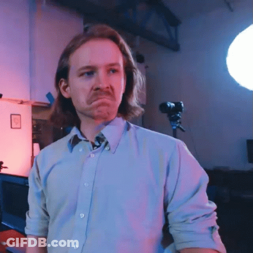 A Man With Long Hair And A Mustache Is Making A Sad Face GIF
