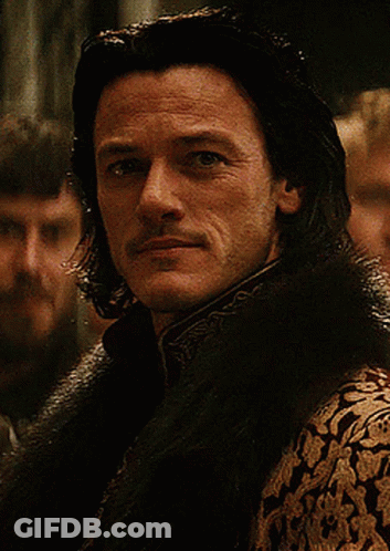 A Man With Long Hair And A Mustache Is Wearing A Fur Collar GIF