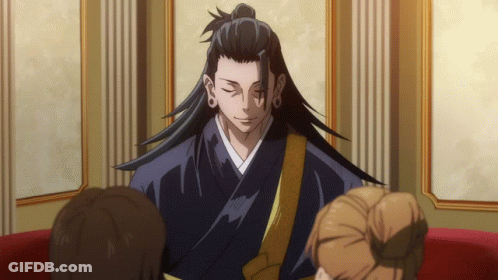 A Man With Long Hair And A Ponytail Is Sitting In A Room With Other People GIF