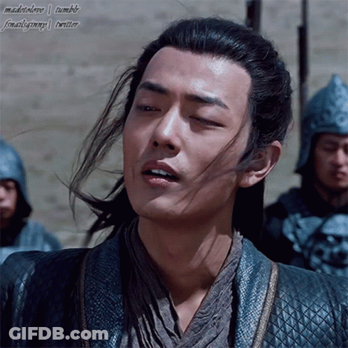 A Man With Long Hair And A Ponytail Is Standing In Front Of Soldiers GIF