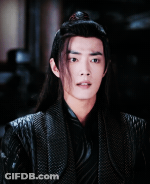 A Man With Long Hair And A Ponytail Is Wearing A Black Jacket GIF