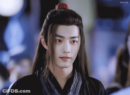A Man With Long Hair And A Red Ponytail GIF