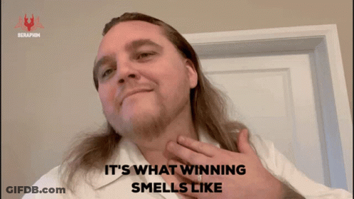 A Man With Long Hair And A White Shirt Says " It 'S What Winning Smells Like " GIF
