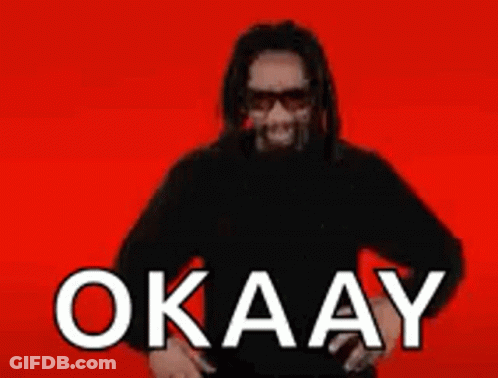 A Man With Long Hair And Sunglasses Is Wearing A Black Shirt And Sunglasses And Says Okay On A Red Background . GIF