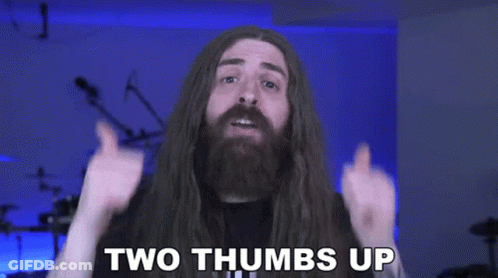 A Man With Long Hair Is Giving Two Thumbs Up GIF