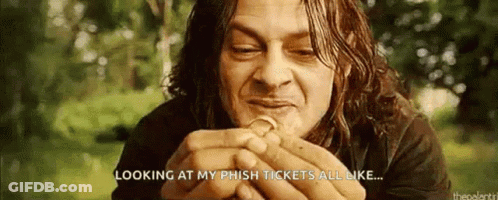 A Man With Long Hair Is Holding A Coin In His Hands . GIF