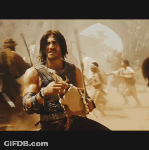 A Man With Long Hair Is Holding A Sword In A Crowd GIF