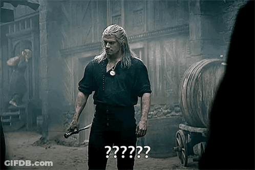 A Man With Long Hair Is Holding A Sword In His Hand In Front Of Barrels . GIF