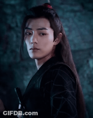 A Man With Long Hair Is Holding A Sword In His Hand GIF