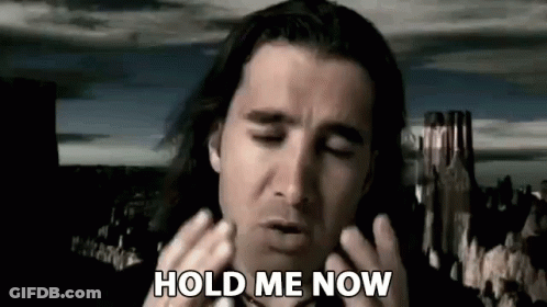 A Man With Long Hair Is Holding His Hands To His Face While Saying `` Hold Me Now '' . GIF