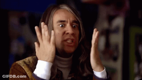 A Man With Long Hair Is Making A Funny Face With His Hands GIF