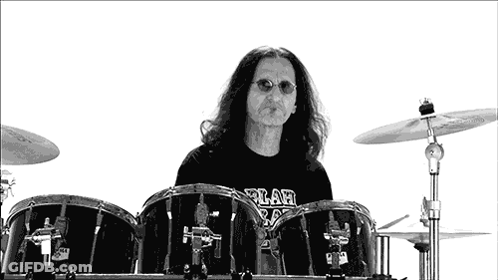 A Man With Long Hair Is Playing Drums With A Shirt That Says ' A ' On It GIF