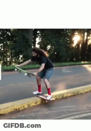 A Man With Long Hair Is Riding A Skateboard Down A Street GIF