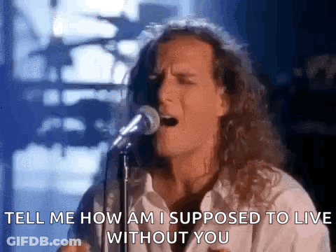 A Man With Long Hair Is Singing Into A Microphone And Says `` Tell Me How Am I Supposed To Live Without You '' GIF