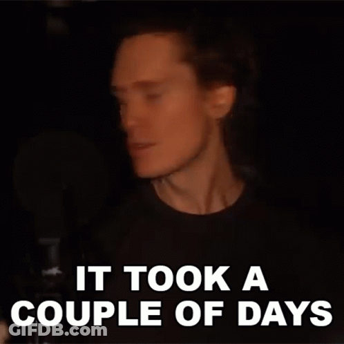 A Man With Long Hair Is Singing Into A Microphone And The Words `` It Took A Couple Of Days '' Are Written Above Him . GIF