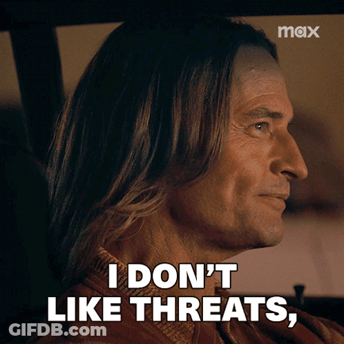 A Man With Long Hair Is Sitting In A Car And Says I Don 'T Like Threats GIF