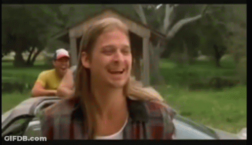 A Man With Long Hair Is Sitting In A Car With Another Man Behind Him . GIF