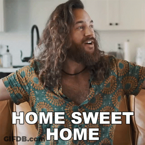 A Man With Long Hair Is Sitting On A Couch And Says Home Sweet Home GIF