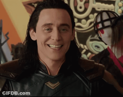 A Man With Long Hair Is Smiling In Front Of A Shield With The Letter O On It GIF