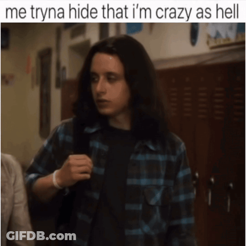 A Man With Long Hair Is Standing In A Hallway With The Caption Me Tryna Hide That I 'M Crazy As Hell . GIF