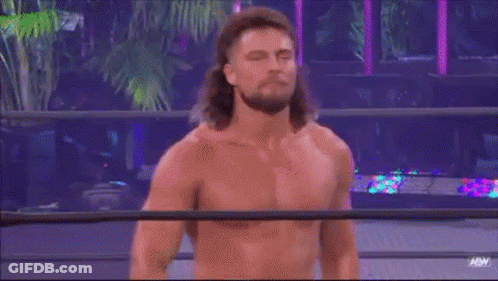 A Man With Long Hair Is Standing In A Wrestling Ring Without A Shirt On . GIF