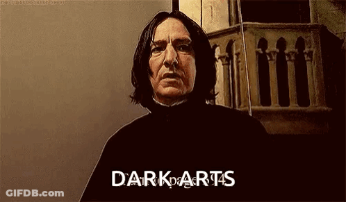 A Man With Long Hair Is Standing In Front Of A Building With The Words `` Dark Arts '' Written On His Face . GIF