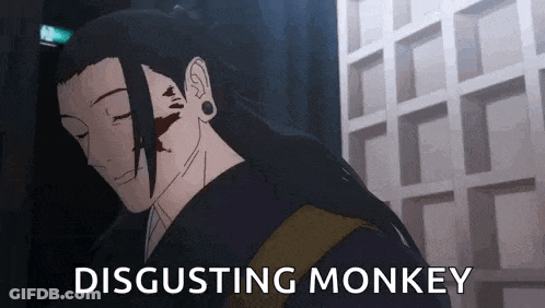 A Man With Long Hair Is Standing In Front Of A Building With The Words Disgusting Monkey Written On It . GIF